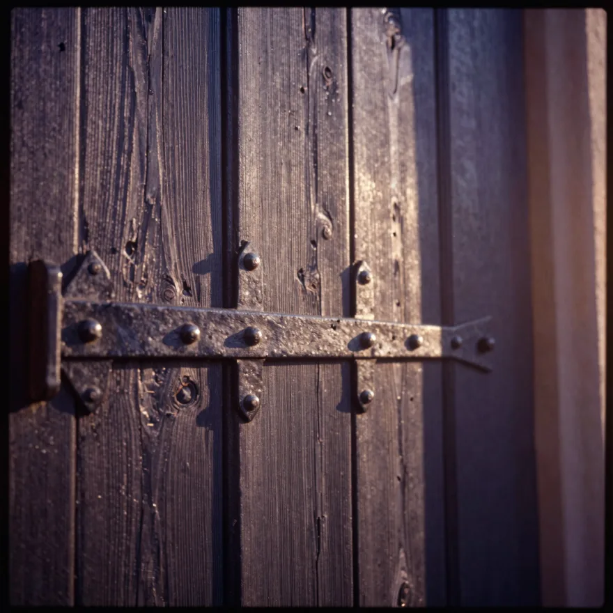 A weathered wooden door with iron hinges.