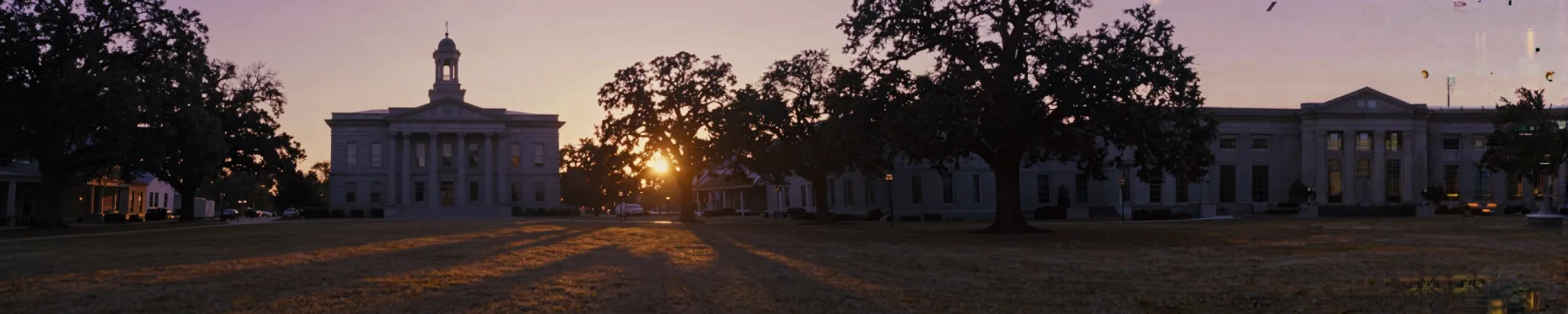 A courthouse square at dawn in a super-ultrawide cinematic strip.